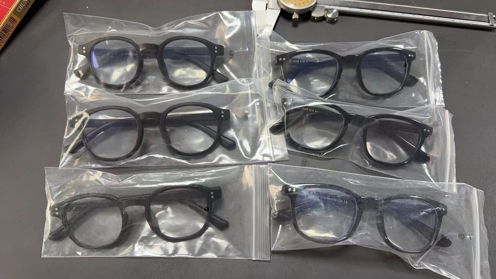 Black optical frames individually packed in transparent PE seal bags — real packaging samples